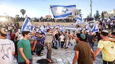  إسرائيليون يحملون الأعلام الإسرائيلية بالقرب من بوابة دمشق في القدس. 